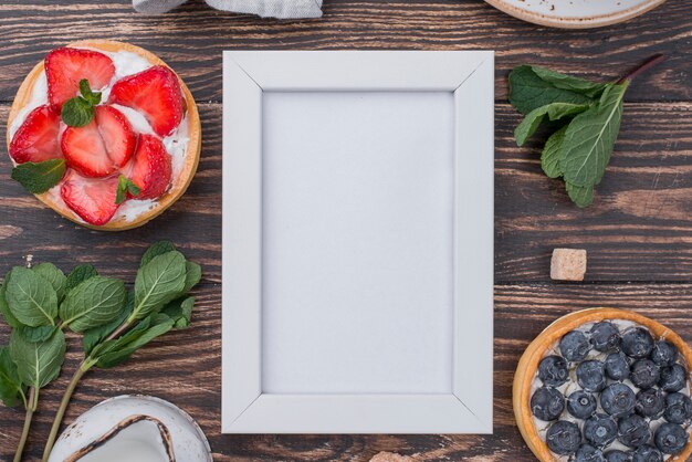 Vue de dessus des tartes aux fruits avec cadre et menthe