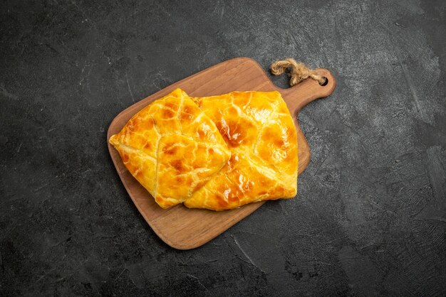 Vue de dessus des tartes à bord de deux tartes sur la planche de cuisine en bois au centre de la table