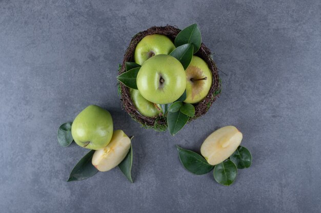 Vue de dessus. Tas de pommes fraîches et de tranches sur fond gris.