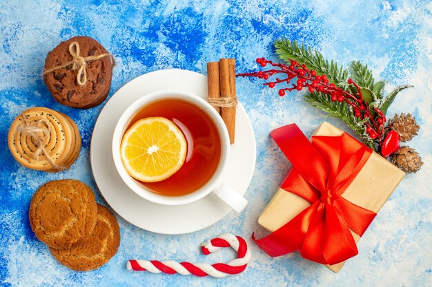 Vue de dessus tasse de biscuits au thé attachés avec une boîte-cadeau de corde sur une table bleue