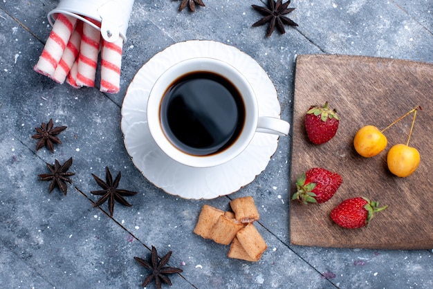 Vue De Dessus De La Tasse De Café Avec Des Biscuits Aux Fraises Rouges Fraîches, Des Bonbons Bâton Rose Sur Un Bureau Lumineux