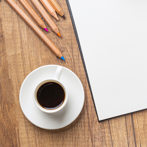 Vue de dessus de la tasse de café avec des crayons de couleur