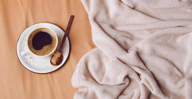 Vue de dessus de la tasse de café du matin sur le lit avec espace copie