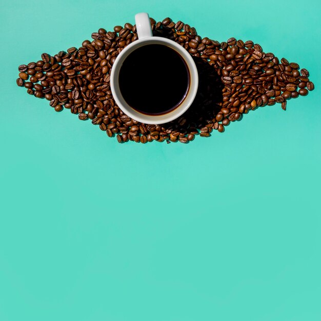 Vue de dessus tasse de café avec des grains