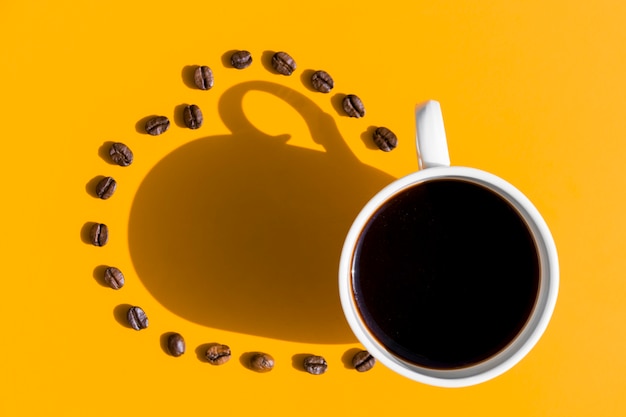 Vue de dessus tasse de café avec des grains