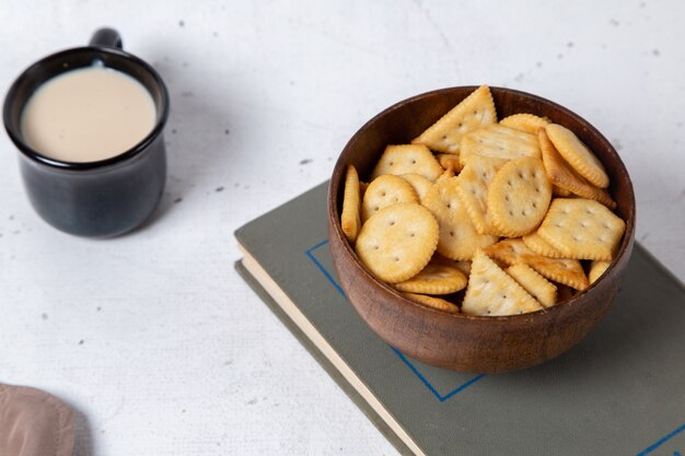 Vue de dessus tasse de lait avec bol de craquelins sur le fond clair cracker croustillant snack