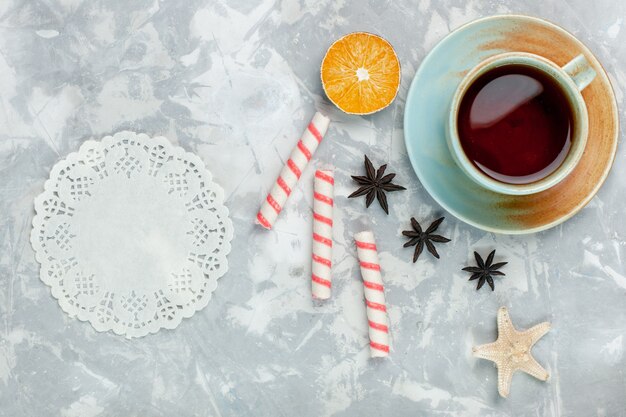 Photo gratuite vue de dessus tasse de thé au citron et bonbons sur fond blanc clair bonbons fruits thé sucré