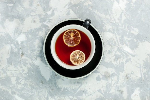 Vue de dessus tasse de thé au citron sur le thé de mur blanc boire des fleurs de citron