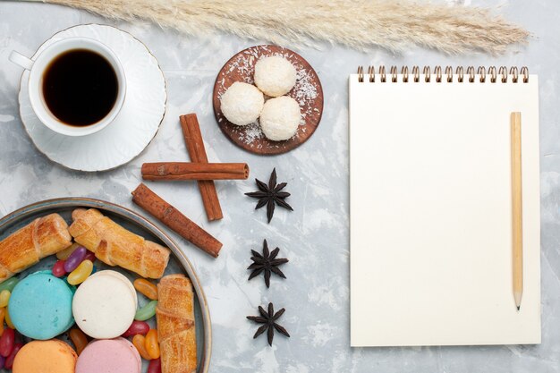 Vue de dessus tasse de thé avec des bagels et des macarons o bureau blanc