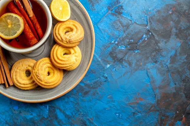 Vue de dessus tasse de thé avec des biscuits sur une table bleue biscuit au thé aux bonbons