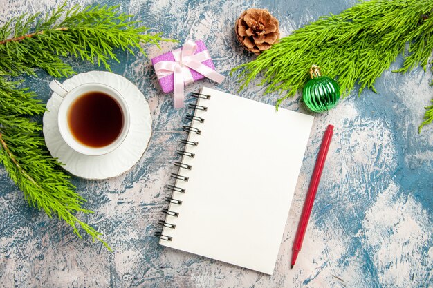 Vue de dessus tasse de thé avec bloc-notes et branche verte