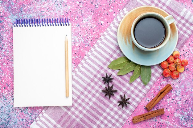 Vue de dessus tasse de thé avec bloc-notes à la cannelle et cerises sur le thé rose backgruond boire la couleur des fruits