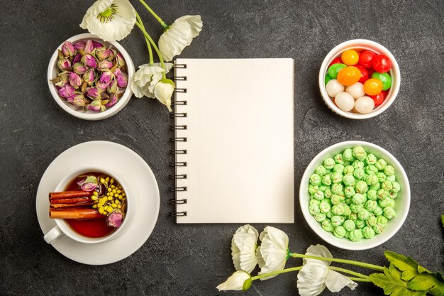 Vue de dessus tasse de thé avec des bonbons sur le bureau gris saveur arc-en-ciel de couleur de thé