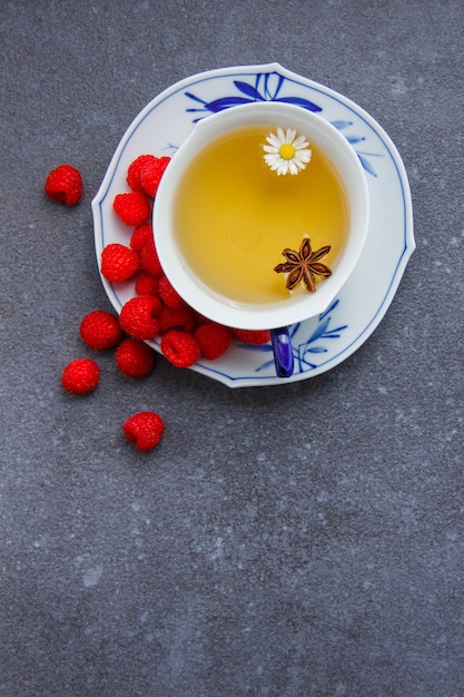 Vue De Dessus Une Tasse De Thé à La Camomille Avec Framboise Dans Une Soucoupe