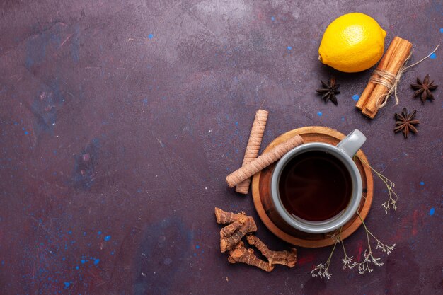 Vue de dessus tasse de thé à la cannelle et au citron sur le thé de bureau foncé couleur douce photo