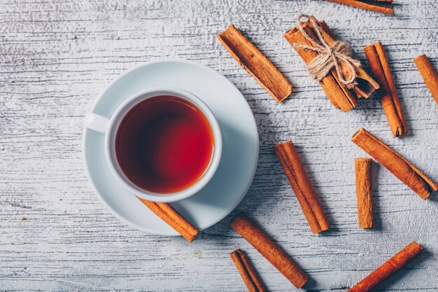 Vue de dessus une tasse de thé à la cannelle sèche sur fond de bois blanc. horizontal