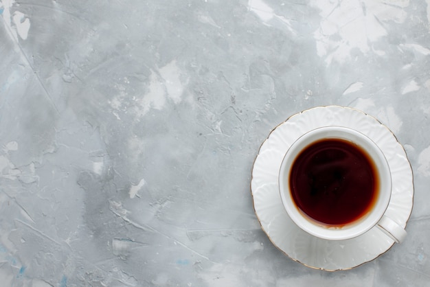 Vue de dessus de la tasse de thé chaud à l'intérieur de la tasse blanche sur blanc, boire du thé sucré