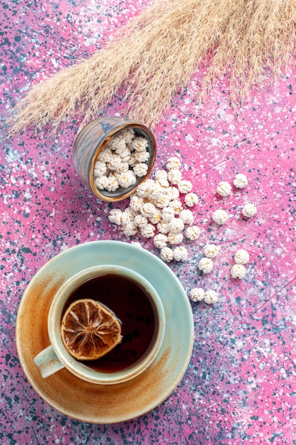 Photo gratuite vue de dessus tasse de thé avec des confitures sucrées blanches sur la surface rose