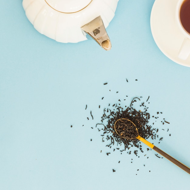 Vue de dessus tasse de thé avec une cuillère pleine de feuilles sèches