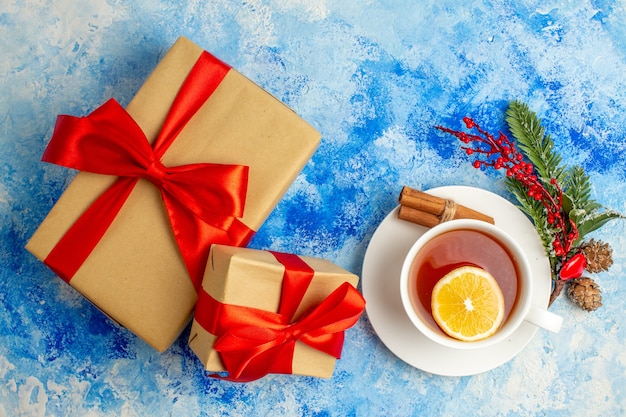 Photo gratuite vue de dessus tasse de thé différentes tailles cadeaux de noël sur table bleue