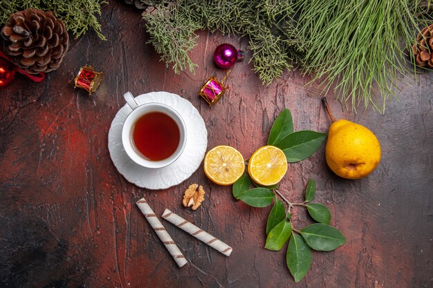 Vue de dessus tasse de thé avec des fruits sur la table sombre thé aux fruits photo sombre