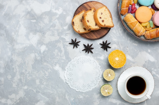 Vue de dessus tasse de thé avec gâteau et bagels sur blanc clair