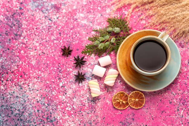 Vue de dessus tasse de thé avec des guimauves sur le bureau rose clair.