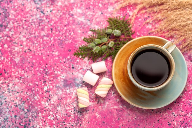 Vue de dessus tasse de thé avec des guimauves sur le bureau rose.