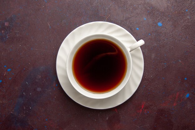 Vue de dessus tasse de thé à l'intérieur de la plaque et tasse sur fond sombre boisson thé couleur photo douce