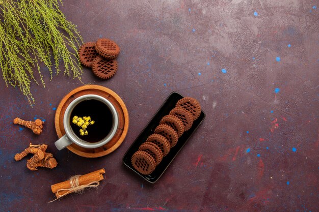 Vue de dessus tasse de thé à l'intérieur de la plaque et tasse sur fond sombre boisson thé couleur photo douce