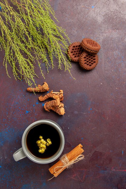 Vue de dessus tasse de thé à l'intérieur de la plaque et tasse sur la surface sombre boisson thé couleur photo douce