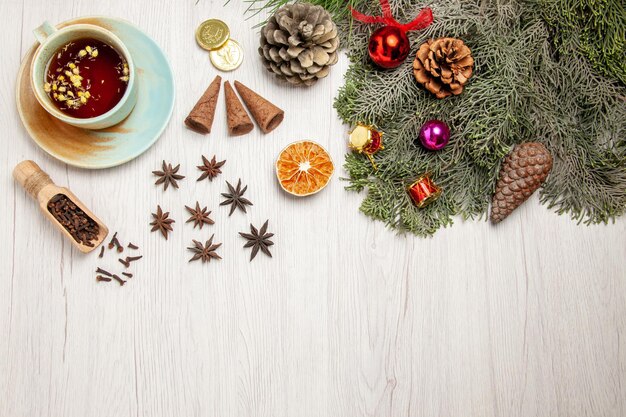 Vue de dessus tasse de thé avec jouets et arbre sur une plante à saveur de fleur de thé de bureau blanc