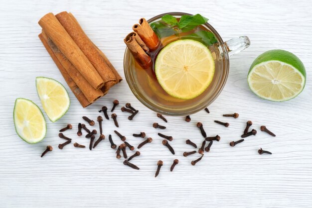 Une vue de dessus tasse de thé à la menthe citron et cannelle sur blanc, bonbons dessert thé