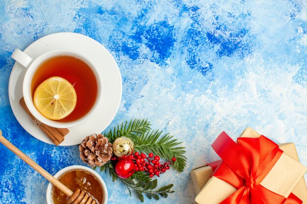 Vue de dessus tasse de thé noël branche d'arbre cadeaux de noël sur l'espace libre de la table bleue