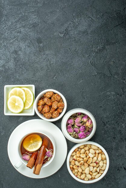 Vue de dessus tasse de thé avec des noix et des bonbons sur une surface sombre des bonbons aux noix de cérémonie du thé