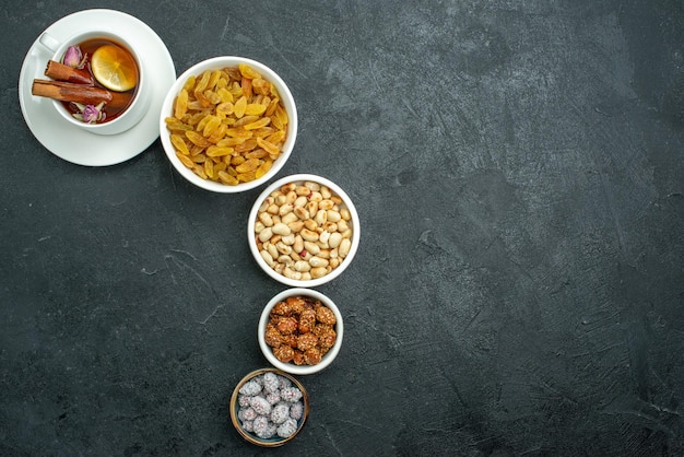 Vue de dessus tasse de thé avec noix et raisins secs sur une surface sombre thé sucré aux noix