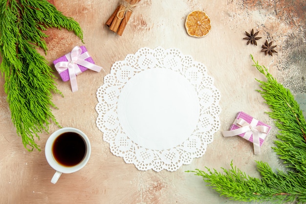 Vue de dessus tasse de thé avec petits cadeaux et branche verte