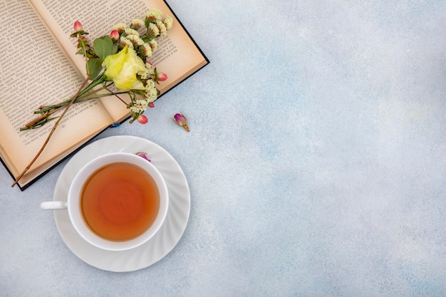 Vue de dessus d'une tasse de thé avec rose jaune sur blanc avec espace copie