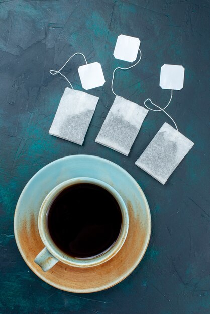 Vue de dessus tasse de thé avec des saveurs sur le bureau sombre boisson thé couleur saveur chaude