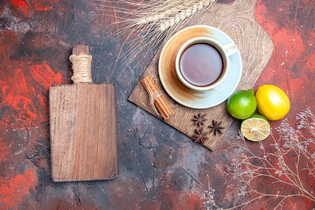 Vue de dessus une tasse de thé une tasse de thé anis étoilé citron cannelle à côté de la planche de bois et des branches