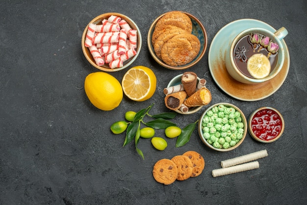 Vue de dessus une tasse de thé une tasse de tisane agrumes bonbons biscuits confiture