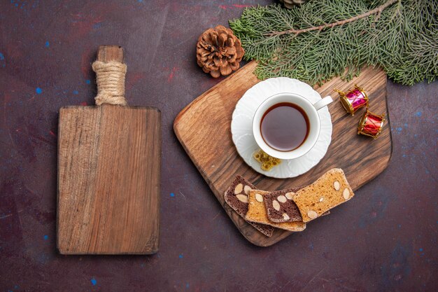 Vue de dessus tasse de thé avec des tranches de gâteau sur l'espace sombre