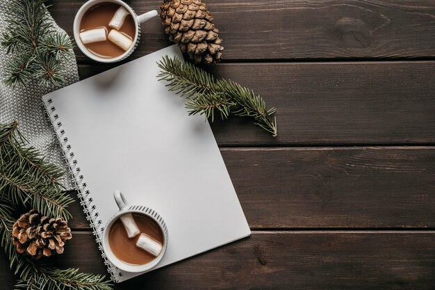 Vue de dessus des tasses de chocolat chaud avec cahier vierge et espace copie