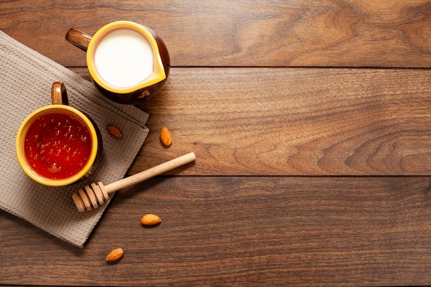 Vue de dessus des tasses de lait et de miel sur la table