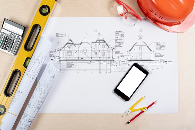 Vue de dessus de téléphone sur la maquette de plans architecturaux