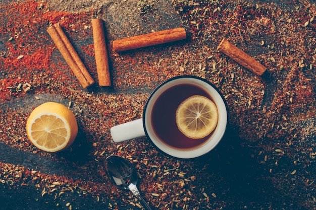 Photo gratuite vue de dessus thé au citron et herbes séchées avec cannelle sèche, cuillère et citron