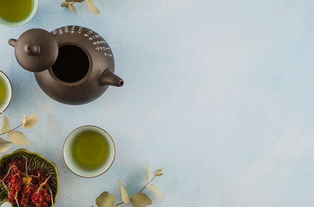 Photo gratuite une vue de dessus de la théière traditionnelle asiatique et des tasses à thé avec des herbes sur fond blanc