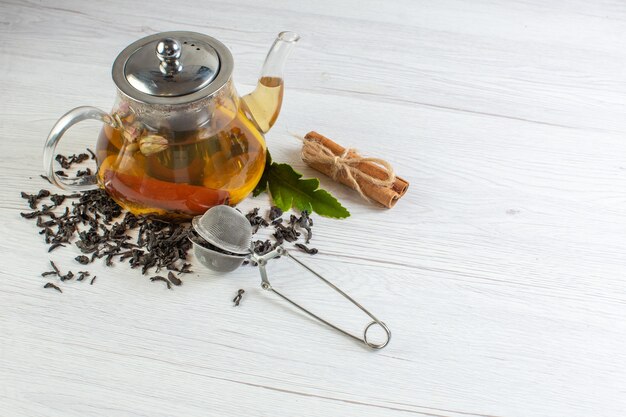 Vue de dessus de tisane dans un pot en verre et citrons verts à la cannelle sur fond blanc