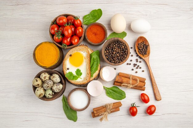 Vue de dessus toasts aux œufs avec assaisonnements et tomates sur fond blanc photo repas du matin petit déjeuner nourriture déjeuner salade couleur