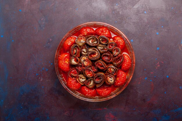 Vue de dessus tomates et aubergines repas de légumes cuits sur la surface sombre